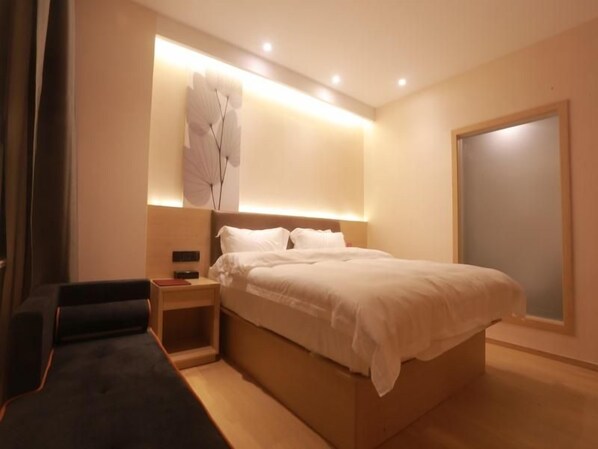 A modern bedroom with a large bed, bedside tables, and a wall-mounted light fixture.