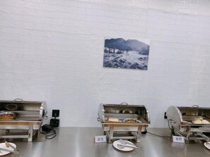 Dispositiu de menjar a bufet amb tres espais d'auto-servei, cadascun amb una varietat de plats. Hi ha indicadors que mostren els tipus d'aliments disponibles.