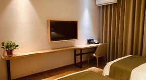 A hotel room with a bed, a desk, a chair, a potted plant, a window, and a curtain. - Greentree Inn Hebei Xingtai Pingxiang County Jianshe Street (Xingtai)