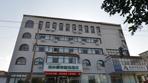 A multi-story building with a large entrance and a sign in Chinese.