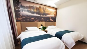 Ein Hotelzimmer mit zwei Betten, einem großen Fenster und einem Wandbild eines Sees.