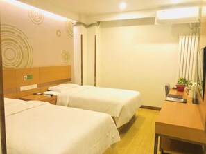 Habitación de hotel con dos camas, un escritorio, una silla y un televisor.