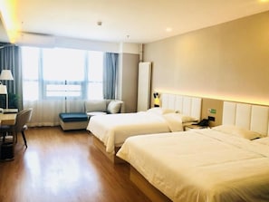 Ein Hotelzimmer mit zwei Betten, einem Schreibtisch und einem Sofa.