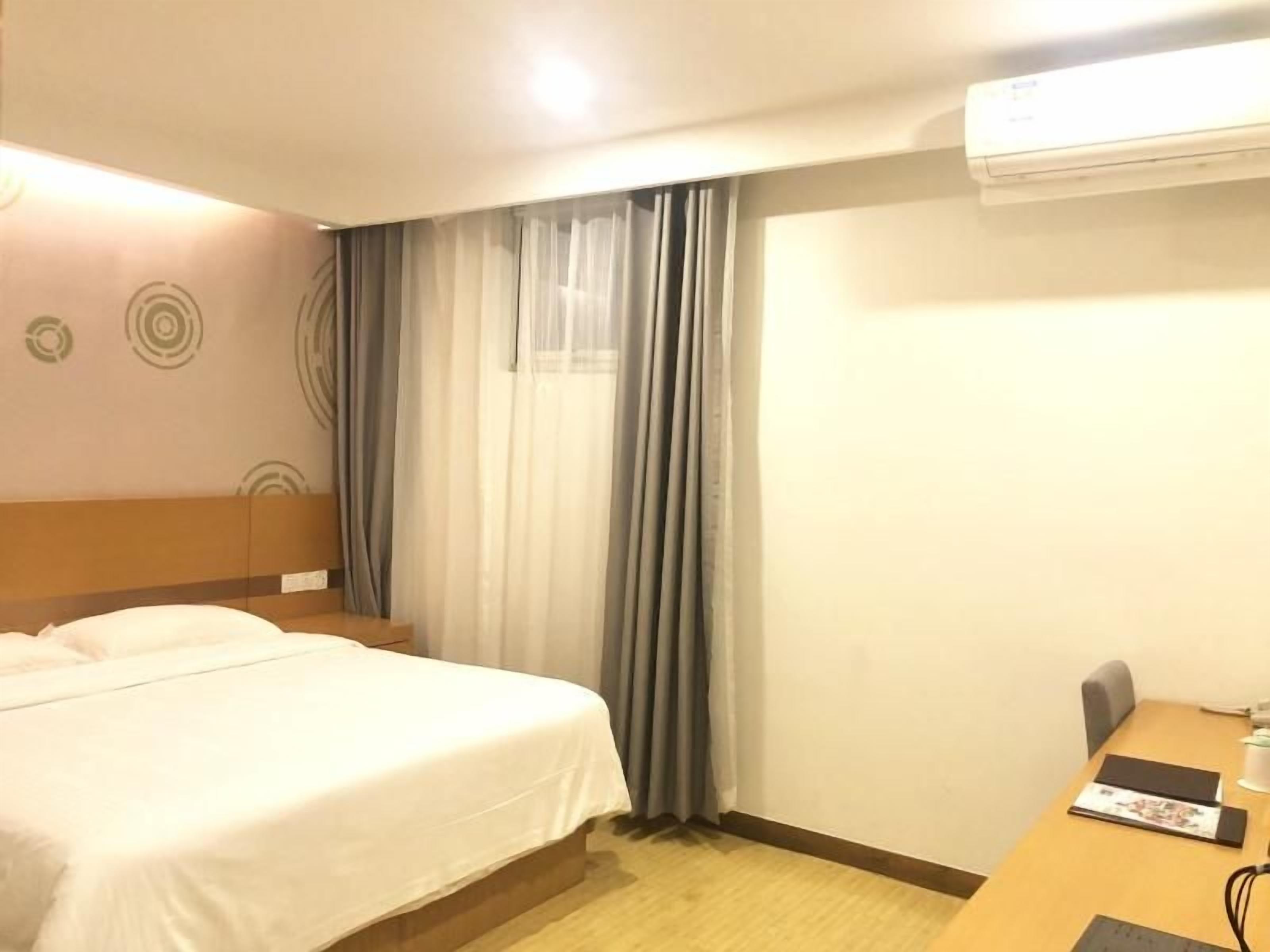 Une chambre d’hôtel équipée d’un lit, d’un bureau et d’un appareil de climatisation.