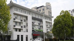 A multi-story building with a modern architectural design, featuring a flat roof and a series of balconies. - Vatica Hotel Anqing Wuyue Square Boai Hospital (Anqing)