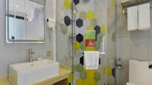 A modern bathroom with a glass shower enclosure, a sink, and a toilet. - Vatica Hotel Anqing Wuyue Square Boai Hospital (Anqing)