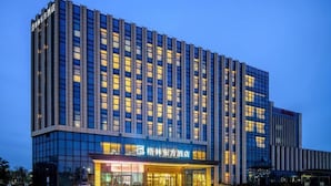 Un moderno edificio de hotel con una entrada destacada y varios pisos.