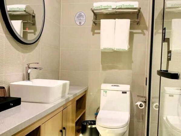 A bathroom with a white sink, a toilet, and a glass shower enclosure. - Greentree Inn Qingdao Laixi High-speed Railway Station Shenzhen Road Express Hotel (Qingdao)