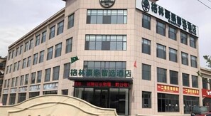 A multi-story building with a sign indicating a business establishment. - Greentree Inn Qingdao Laixi High-speed Railway Station Shenzhen Road Express Hotel (Qingdao)