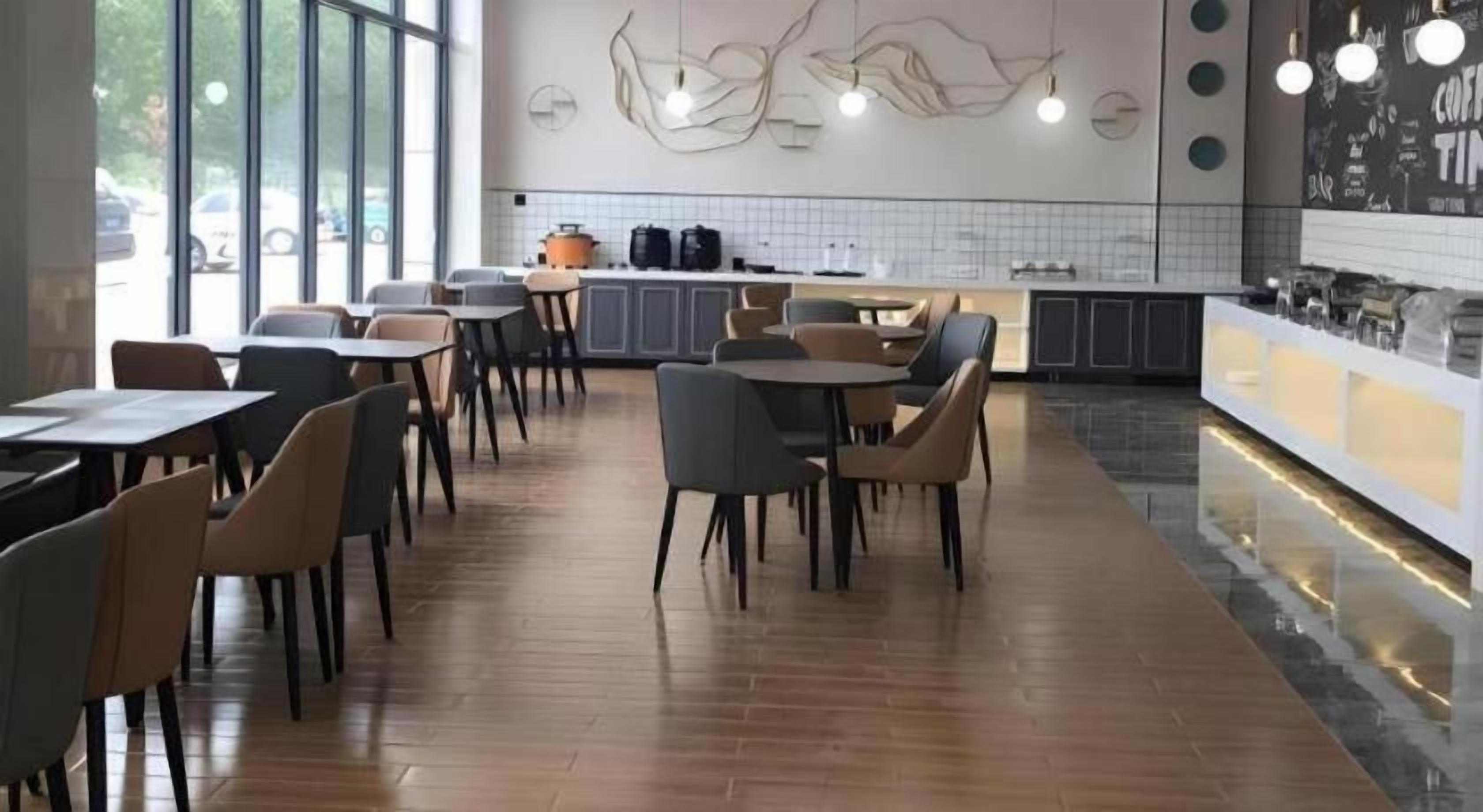 A modern cafe interior with wooden flooring, round tables, and chairs.