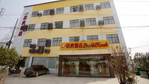A multi-story hotel with a yellow facade and multiple air conditioning units. - Shell Nanjing City Qixia District Baguazhou Hotel (Nanjing)