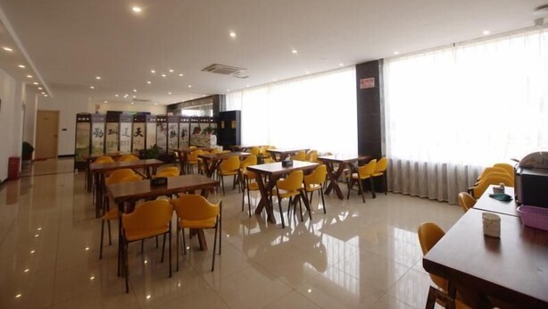 A spacious dining area with yellow chairs and tables, large windows, and a clean, modern design. - Shell Nanjing City Qixia District Baguazhou Hotel (Nanjing)