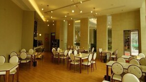 A spacious dining area with multiple tables and chairs, high ceilings with pendant lighting, and a modern interior design. - Greentree Inn Fuyang Yinzhou District Nanjing Road Teachers College (Fuyang)
