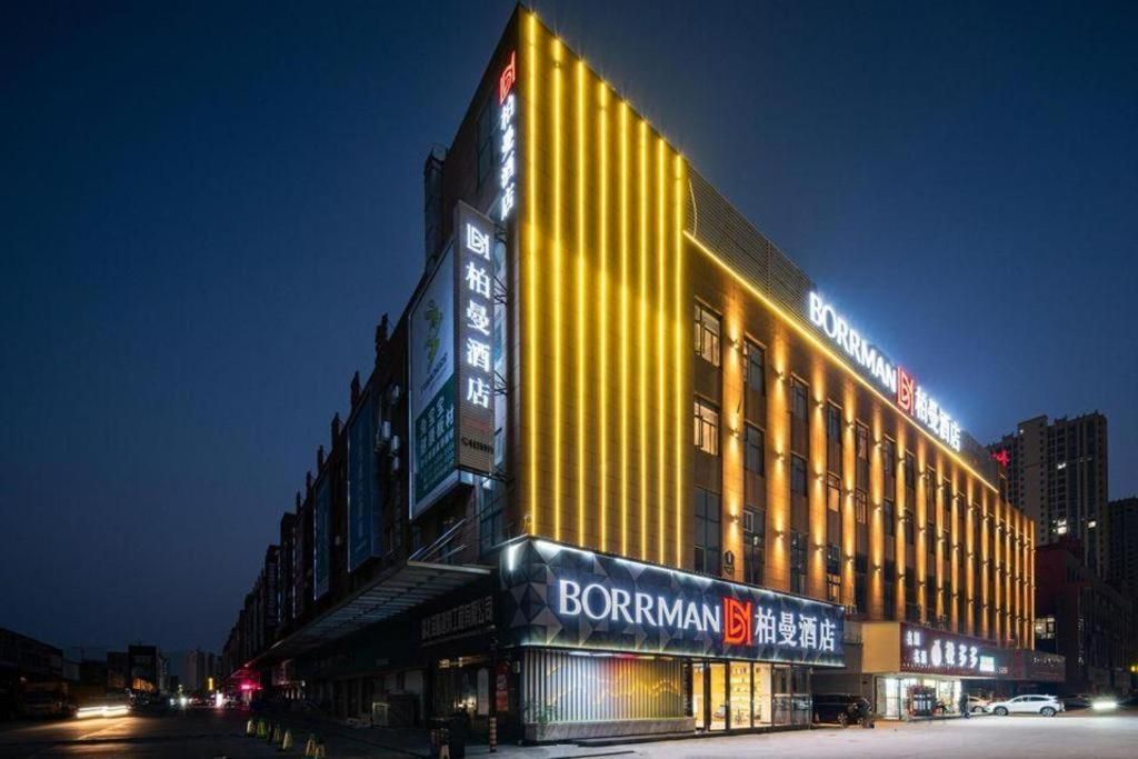 A hotel with a prominent sign, vertical lighting, and a modern facade.