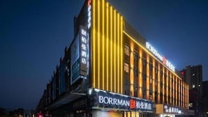 Un hotel con un llamativo letrero 'BORRMAN', varios pisos y un diseño arquitectónico moderno.