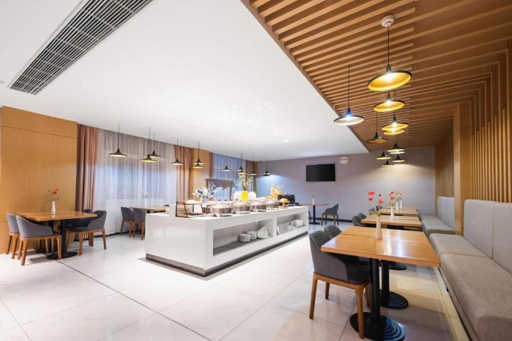 A modern dining area with a central buffet, multiple seating options, and pendant lighting.