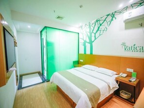 A hotel room with a bed, a nightstand, a green wardrobe, and a wall with a tree decal. - Vatica Hefei Baishuiba BHG Hotel (Hefei)