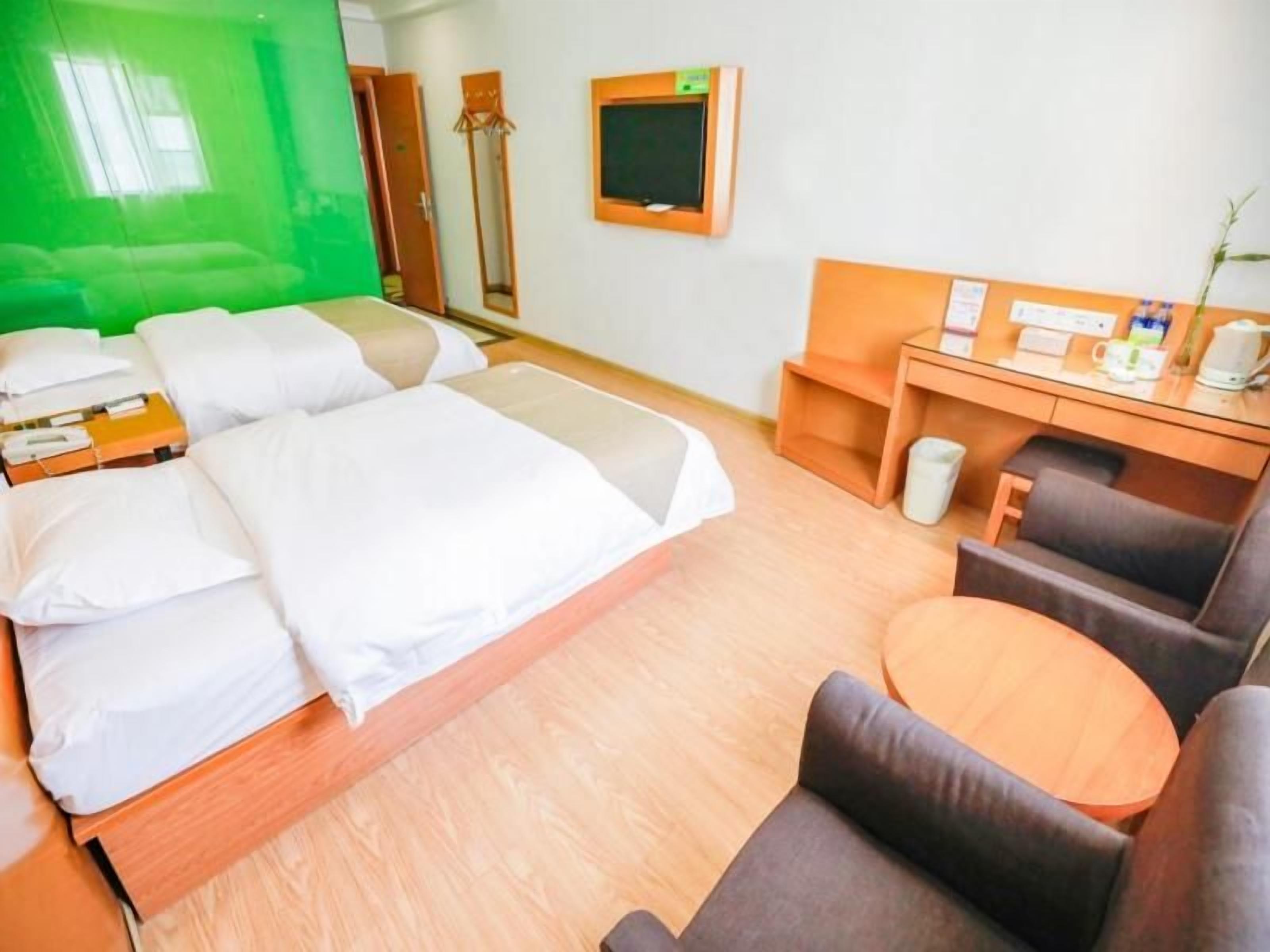 Ein Hotelzimmer mit Bett, Schreibtisch, Stuhl und einem kleinen Tisch.