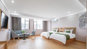 Una habitación de hotel moderna con dos camas, un escritorio y un televisor.