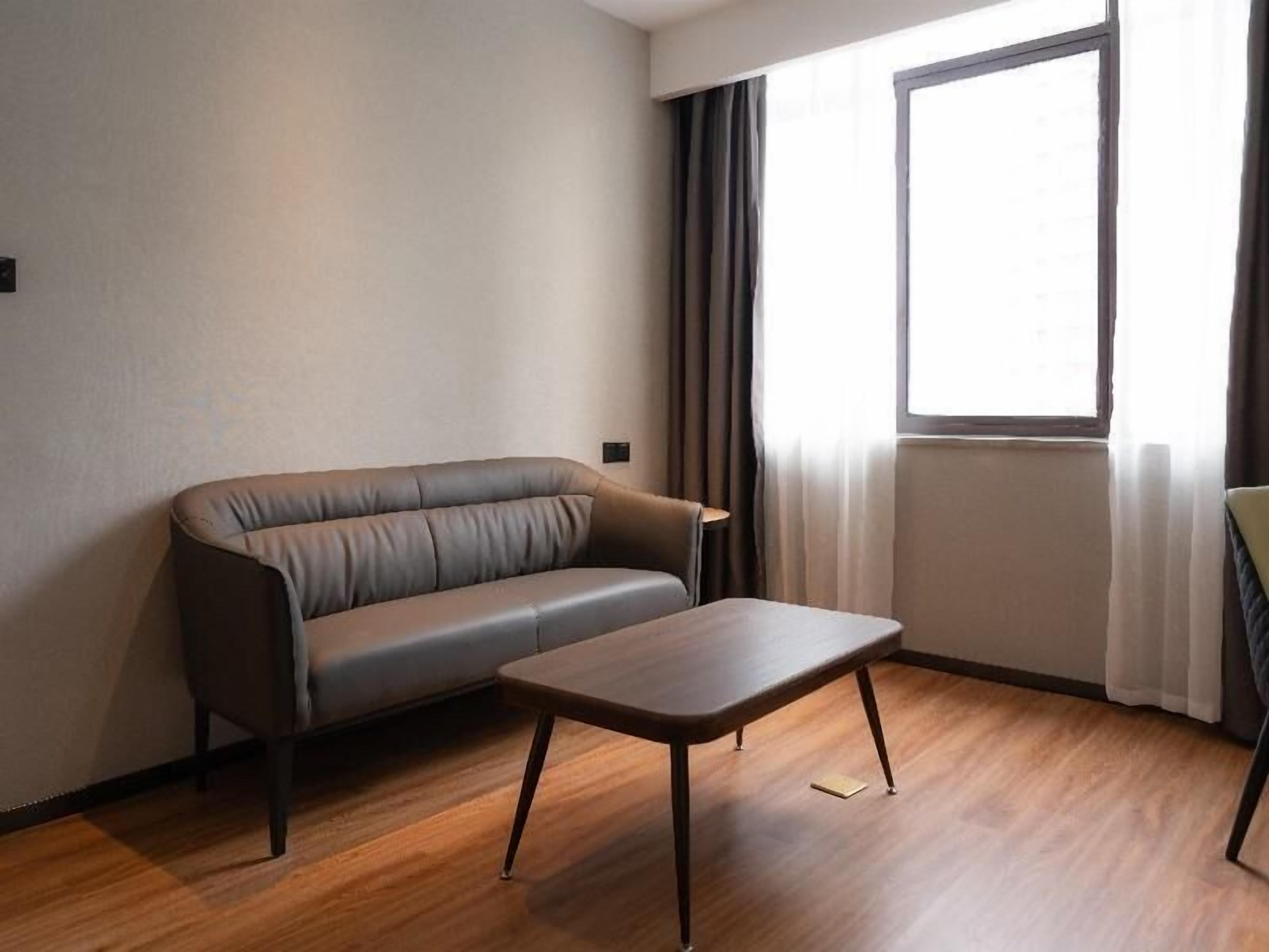 Un salon moderne avec un canapé en cuir et une table basse en bois.