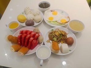 A table with various dishes including dumplings, fried eggs, noodles, and other food items. - Greentree Inn Express Hefei Yaohai Wanda Minghuang Road (Hefei)