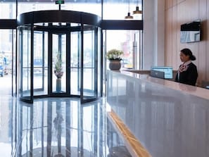 A lobby with a revolving door, a reception desk, and a large window offering a view of the street. - Greentree Inn Express Hefei Yaohai Wanda Minghuang Road (Hefei)