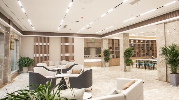 Eine geräumige Lobby mit Sitzbereichen, einem Empfangsbereich und einer Bibliothek.