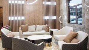 Ein moderner Lounge-Bereich mit einer Couch, Sesseln und einem Couchtisch.