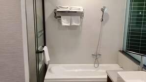 A modern bathroom with a bathtub, a shower, and a sink. - Green Haotai Zhixuan Hotel (Shangqiu)