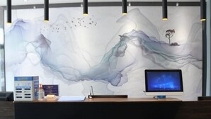 Un comptoir d’accueil équipé d’un écran d’ordinateur, d’un distributeur d’eau et d’une boîte de mouchoirs.
