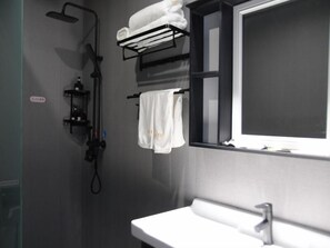 Une salle de bain moderne avec une douche, un lavabo et une fenêtre.