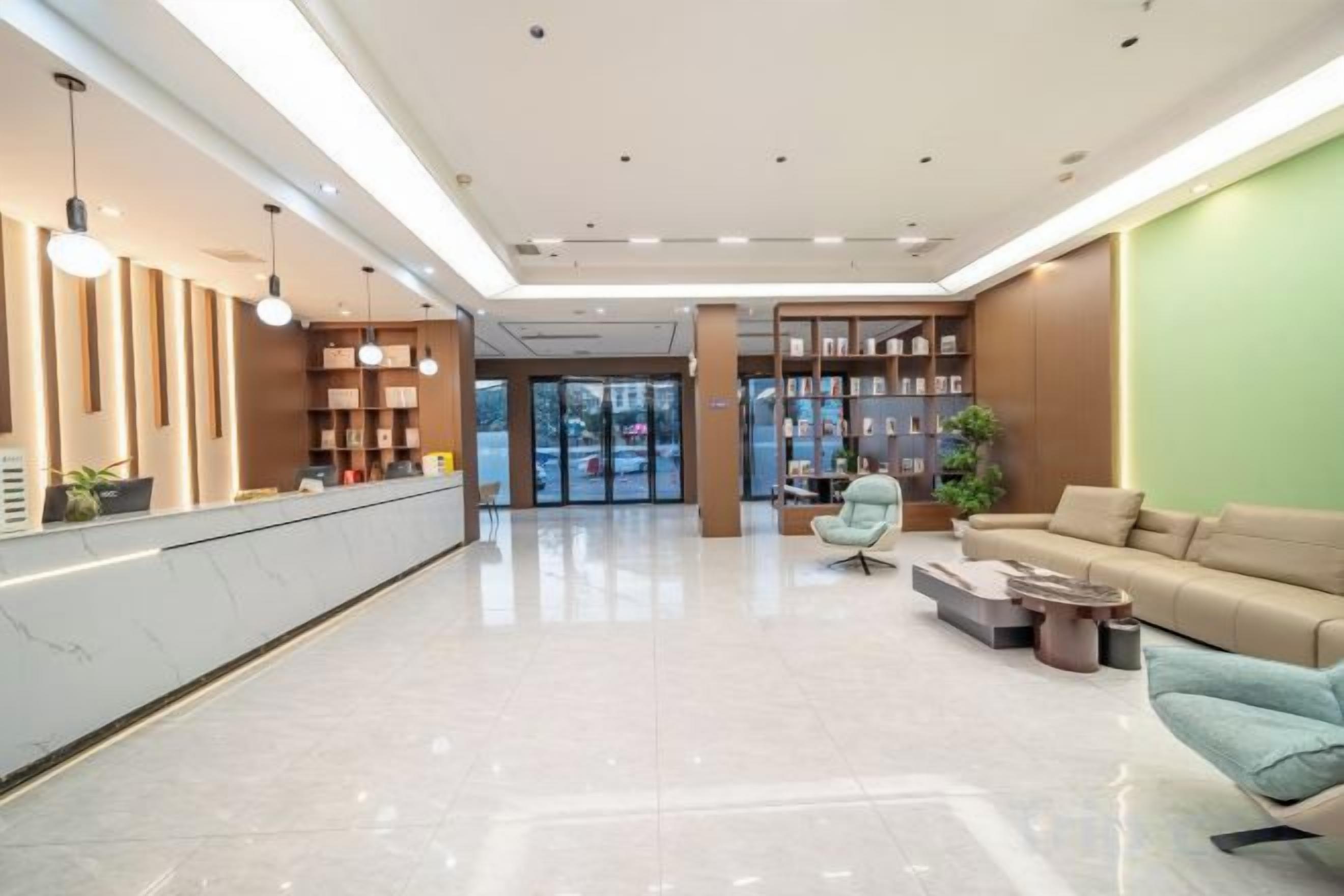 Un moderno vestíbulo de hotel con mostrador de recepción, zona de estar y una estantería.