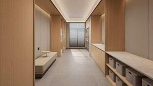 A modern hallway with wooden paneling, a bench, and storage bins.
