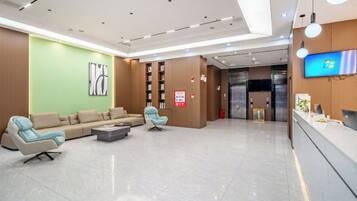 A modern hotel lobby with a reception desk, seating area, and a large screen displaying the Windows logo.