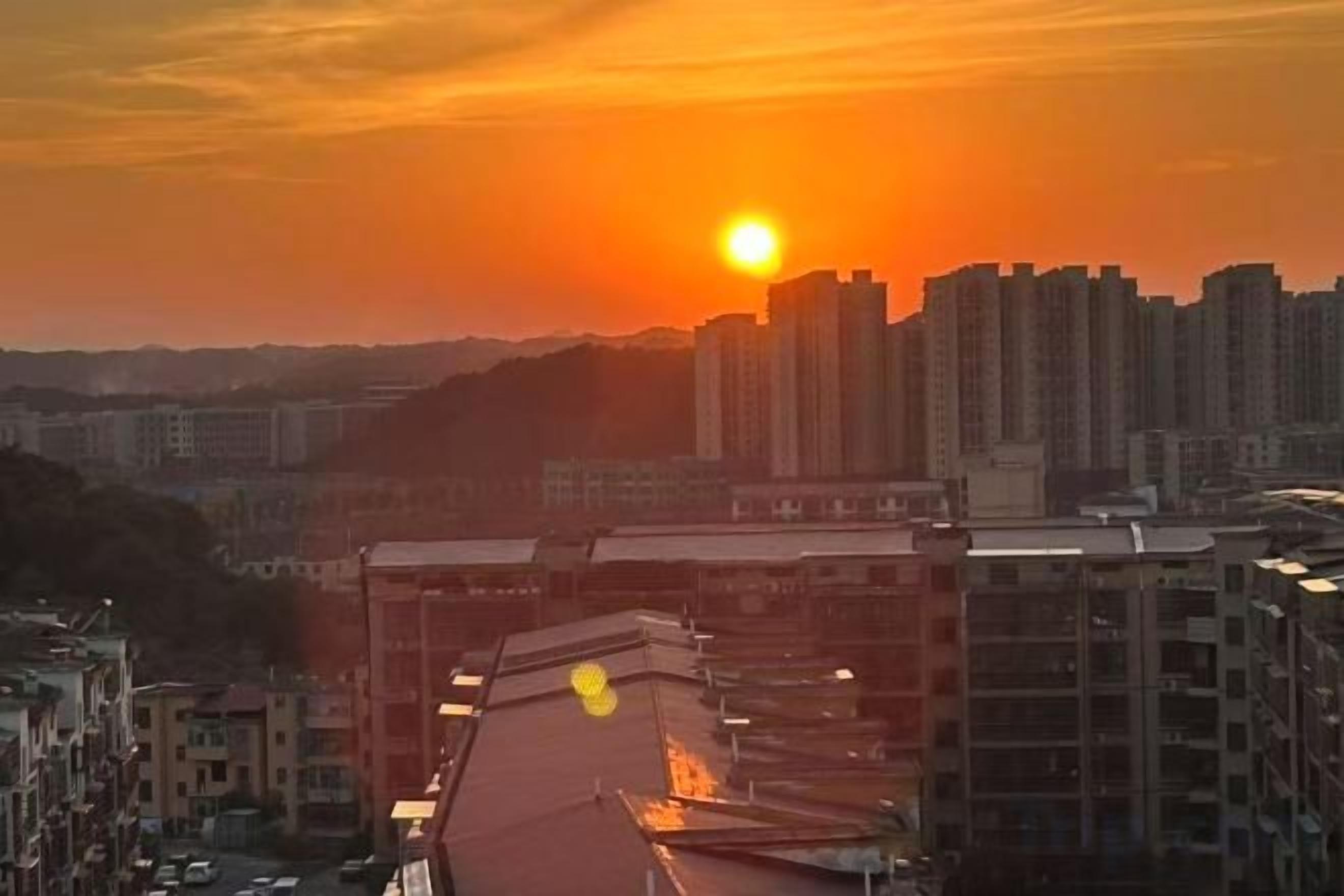 A cityscape with high-rise buildings and a sunset.