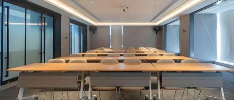A conference room with a long table, chairs, and a projector.