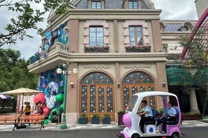 A building with a large arched entrance and a mural on the side.
