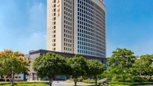 A tall, modern building with a grid-like facade and a sign in a foreign script on the side. - Greentree Eastern Bengbu Huaishang District Wanda Plaza Haijixing Hotel (Bengbu)