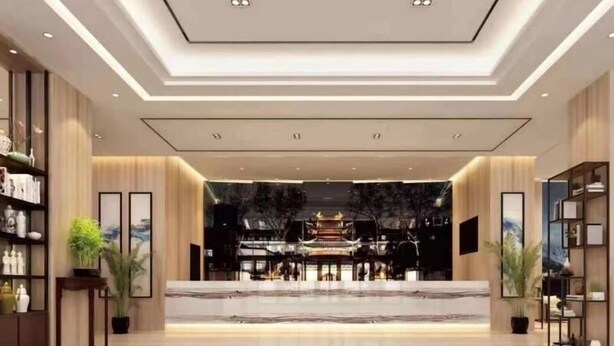 A spacious lobby with a central marble reception desk, flanked by bookshelves and potted plants. - Greentree Eastern Bengbu Huaishang District Wanda Plaza Haijixing Hotel (Bengbu)