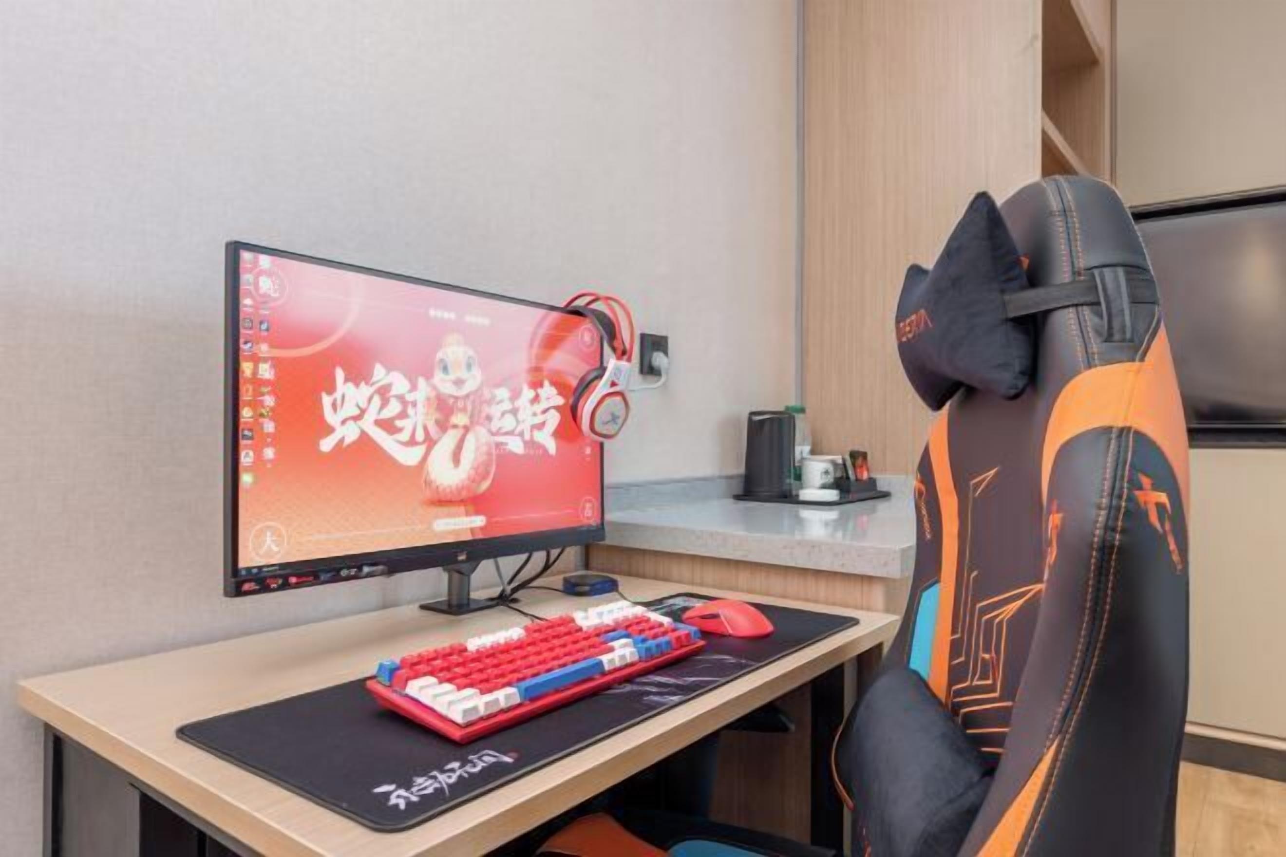 Un ordinateur installé sur un bureau, comprenant un écran, un clavier et un casque audio.