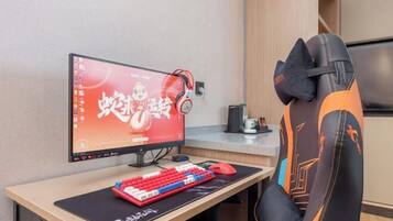Un ordinateur installé sur un bureau, comprenant un écran, un clavier et un casque audio.