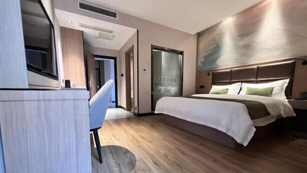 A modern hotel room with a wooden floor, a bed with white bedding, a desk with a chair, and a large window. - GreenTree Inn (Nantong Shanghe Plaza) (Nantong)