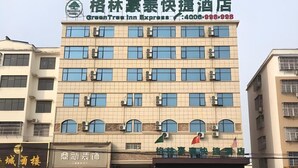 A multi-story hotel with a prominent sign for GreenTree Inn Express. - Greentree Inn Xinyang Gushi County Liaocheng Avenue (Xinyang)