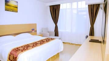 Una habitación de hotel con cama, mesita de noche y escritorio.