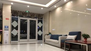 A modern lobby with a reception desk, a seating area with a sofa and a table, and a glass door entrance. - Greentree Alliance Texas Railway Station Municipal Hospital Hotel (Dezhou)