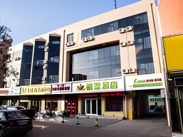 A building with multiple storefronts, including a restaurant with a green sign.