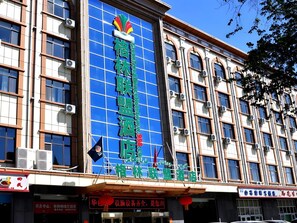 Un hôtel dont l’enseigne, bien visible, présente un logo et des caractères chinois.