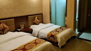Quarto de hotel com duas camas, uma mesa de cabeceira e uma porta para o banheiro.