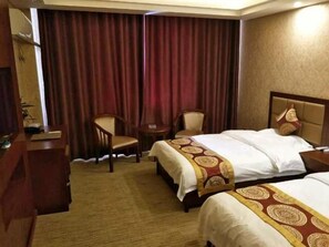 Une chambre d’hôtel avec deux lits, un bureau et une chaise.
