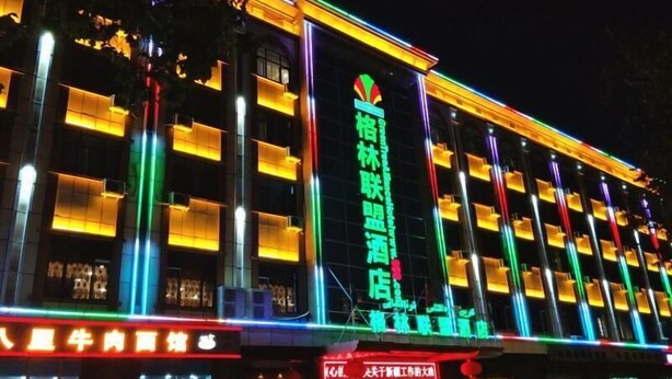 Um hotel com vários andares, varandas e fachada bem iluminada.